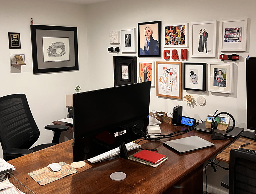 office with white walls filled with gallery style art made by indie makers